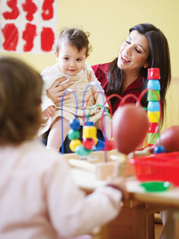 female toddler and 2-3 years girl playing with maraca in kindergarten. Vertical shape