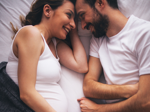 happy-preggers-couple-in-bed