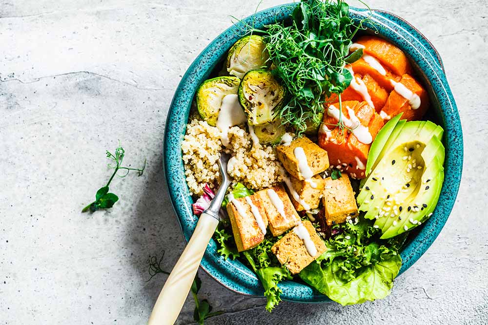 Buddha bowl with quinoa, tofu, avocado, sweet potato, brussels s